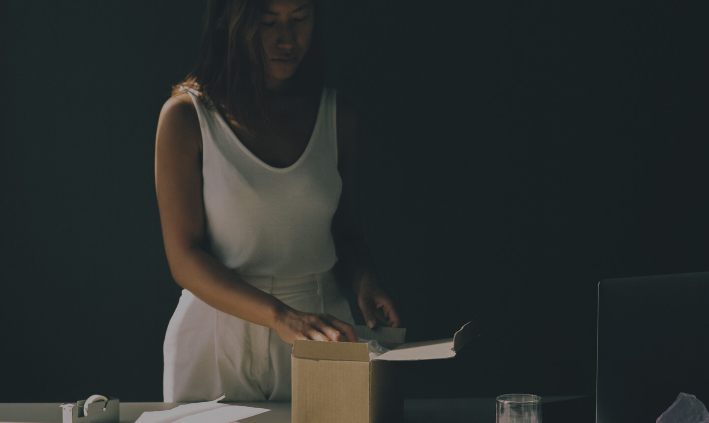 Woman in a white dress unpacking glasses