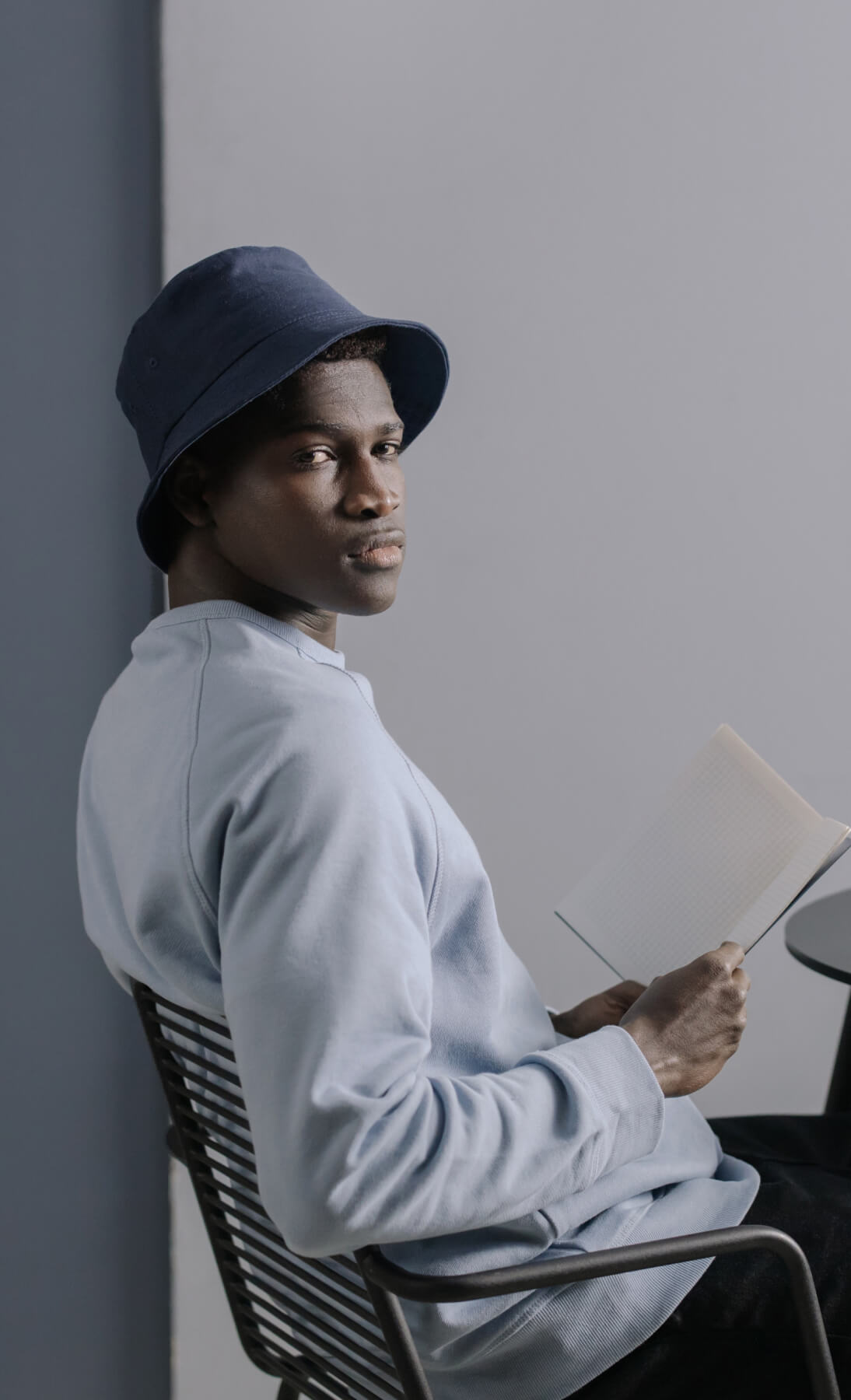 Person with a notebook in hand looking at the viewer