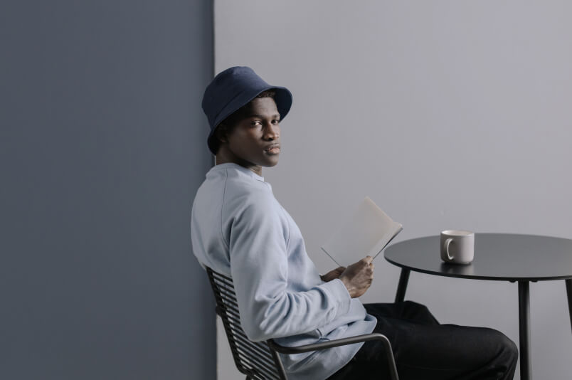 Man holding a book looking at the viewer